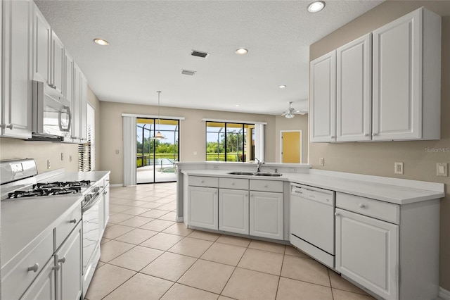 8118 Stirling Falls Cir, Sarasota, FL 34243 - kitchen with gas range, dishwasher, white cabinets, a peninsula, and recessed lighting