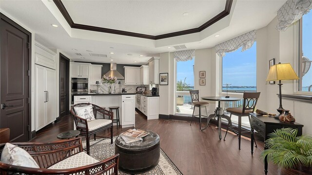 420 Golden Gate Pt Unit 200A, Sarasota, FL 34236 - living area with dark wood-style floors, a tray ceiling, and crown molding