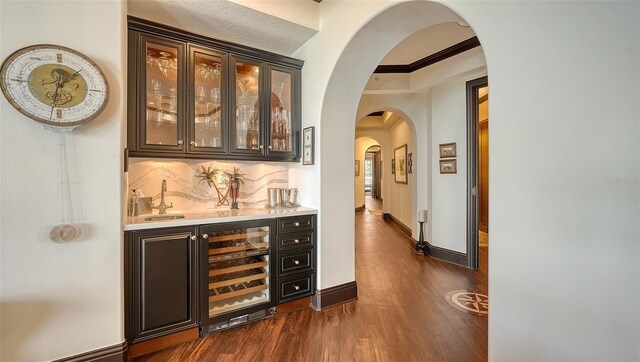 420 Golden Gate Pt Unit 200A, Sarasota, FL 34236 - indoor bar featuring arched walkways, wine cooler, dark wood-style floors, and tasteful backsplash