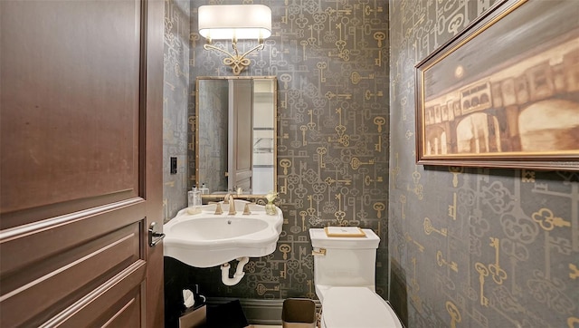 420 Golden Gate Pt Unit 200A, Sarasota, FL 34236 - bathroom with wallpapered walls, toilet, and a sink