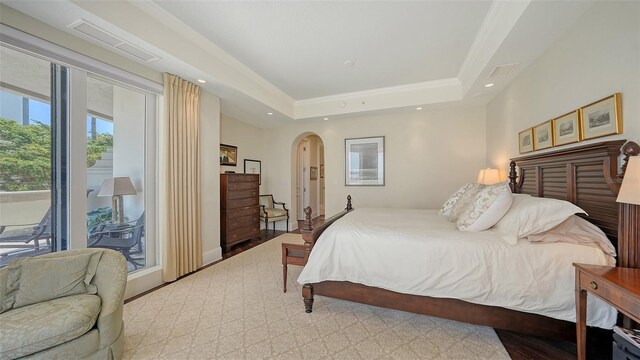 420 Golden Gate Pt Unit 200A, Sarasota, FL 34236 - bedroom with access to exterior, arched walkways, recessed lighting, and a tray ceiling