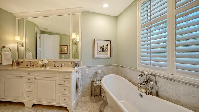 420 Golden Gate Pt Unit 200A, Sarasota, FL 34236 - bathroom with a freestanding bath, tile walls, double vanity, and recessed lighting