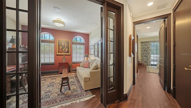 420 Golden Gate Pt Unit 200A, Sarasota, FL 34236 - hall with wood finished floors, healthy amount of natural light, recessed lighting, baseboards, and a textured ceiling