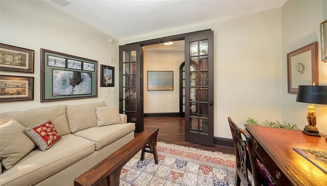 420 Golden Gate Pt Unit 200A, Sarasota, FL 34236 - living area featuring wood finished floors, french doors, and baseboards