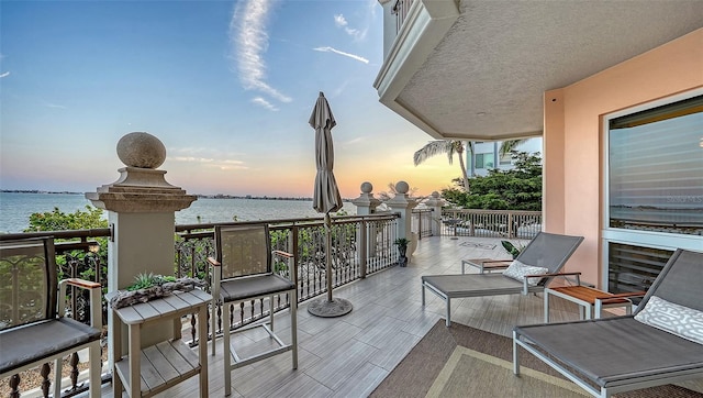 420 Golden Gate Pt Unit 200A, Sarasota, FL 34236 - balcony at dusk featuring a water view