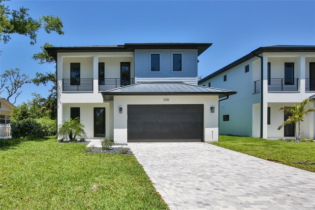 2335 Oak Ter, Sarasota, FL 34231 - modern home with a balcony, a standing seam roof, stucco siding, and an attached garage