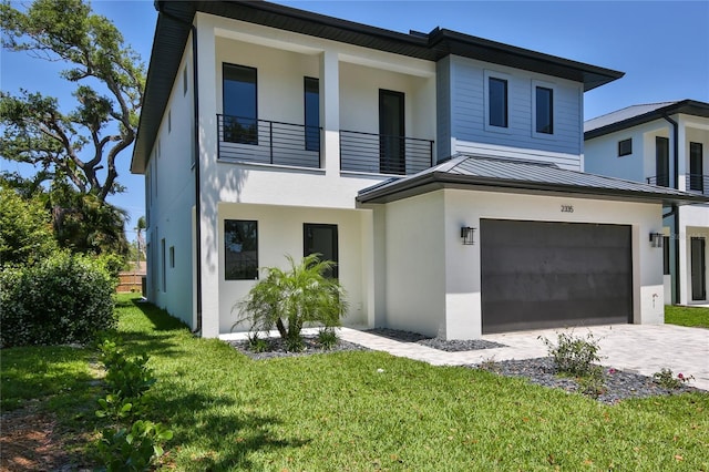 2335 Oak Ter, Sarasota, FL 34231 - view of front of house featuring a standing seam roof, a balcony, an attached garage, stucco siding, and metal roof