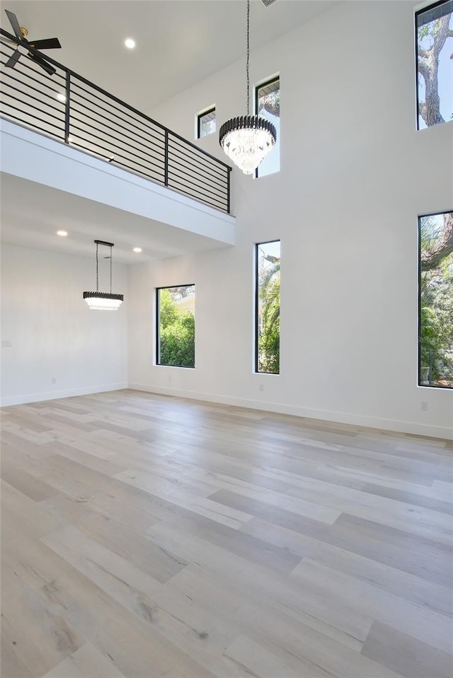 2335 Oak Ter, Sarasota, FL 34231 - unfurnished room featuring a chandelier, light wood-style flooring, a high ceiling, baseboards, and recessed lighting