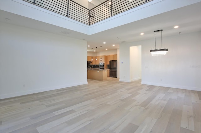 2335 Oak Ter, Sarasota, FL 34231 - unfurnished living room with light wood-style floors, recessed lighting, baseboards, and a high ceiling