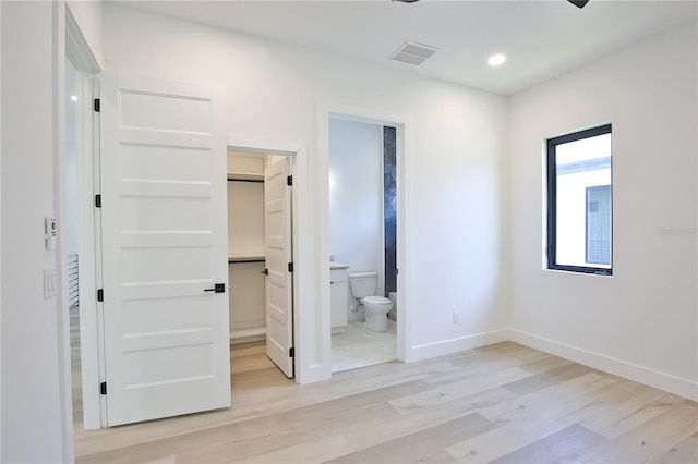 2335 Oak Ter, Sarasota, FL 34231 - unfurnished bedroom with a spacious closet, light wood-style flooring, baseboards, ensuite bathroom, and recessed lighting