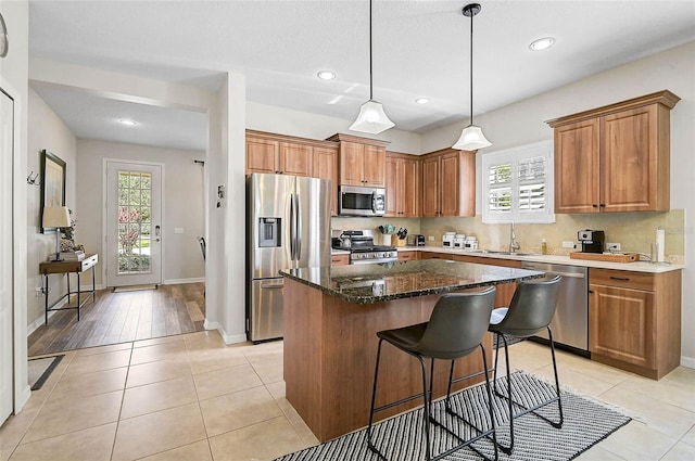 12149 Forest Park Cir, Bradenton, FL 34211 - kitchen with stainless steel appliances, a sink, a kitchen island, brown cabinetry, and recessed lighting