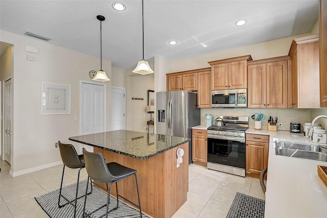 12149 Forest Park Cir, Bradenton, FL 34211 - kitchen with stainless steel appliances, a sink, light tile patterned floors, a kitchen island, and recessed lighting