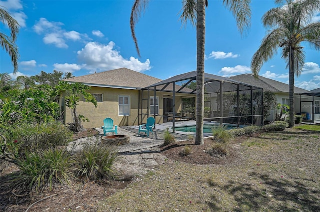 12149 Forest Park Cir, Bradenton, FL 34211 - back of property featuring stucco siding, a fire pit, a patio area, an outdoor pool, and a lanai