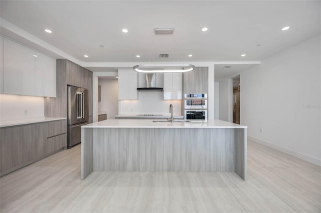 301 Quay Commons Unit 1711, Sarasota, FL 34236 - kitchen with modern cabinets, stainless steel appliances, wall chimney exhaust hood, a spacious island, and recessed lighting