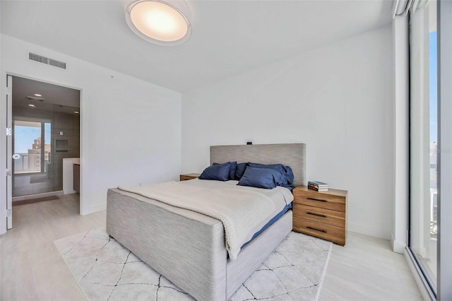 301 Quay Commons Unit 1711, Sarasota, FL 34236 - bedroom with light wood-style flooring and ensuite bath