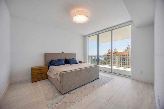 301 Quay Commons Unit 1711, Sarasota, FL 34236 - bedroom featuring floor to ceiling windows, access to exterior, and baseboards