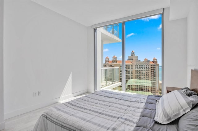 301 Quay Commons Unit 1711, Sarasota, FL 34236 - bedroom with a wall of windows, baseboards, wood finished floors, and a view of city