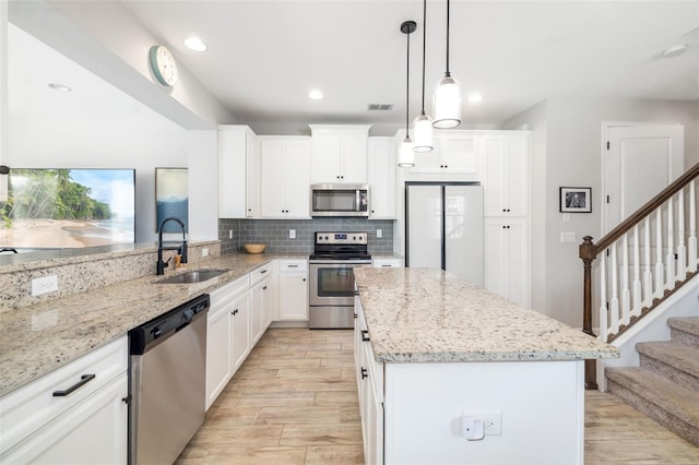 kitchen with appliances with stainless steel finishes, a sink, backsplash, light stone counters, and recessed lighting