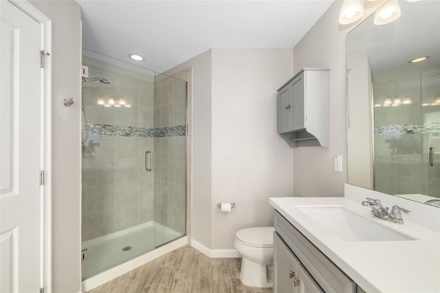 full bathroom featuring baseboards, a stall shower, vanity, recessed lighting, and toilet