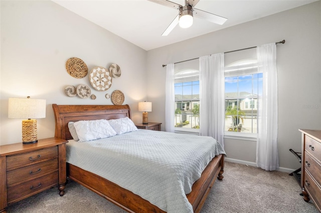 bedroom featuring light carpet, baseboards, and a ceiling fan