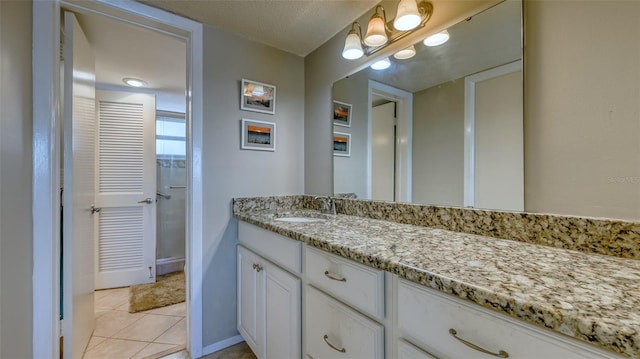 4420 Exeter Dr Unit L104, Longboat Key, FL 34228 - bathroom with vanity, tile patterned floors, and baseboards