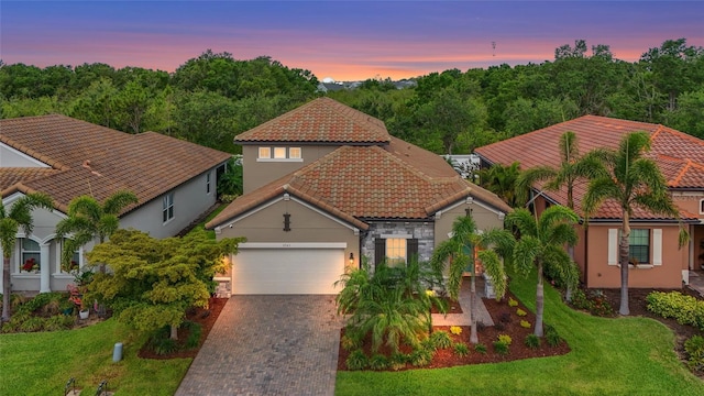 2745 62nd Ave E, Ellenton, FL 34222 - mediterranean / spanish home with an attached garage, a tiled roof, decorative driveway, stucco siding, and stone siding