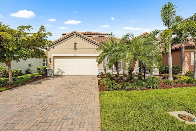 2745 62nd Ave E, Ellenton, FL 34222 - mediterranean / spanish-style house featuring stucco siding, decorative driveway, stone siding, a garage, and a tile roof