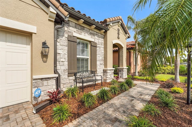 2745 62nd Ave E, Ellenton, FL 34222 - view of exterior entry with stone siding, stucco siding, covered porch, and a tiled roof