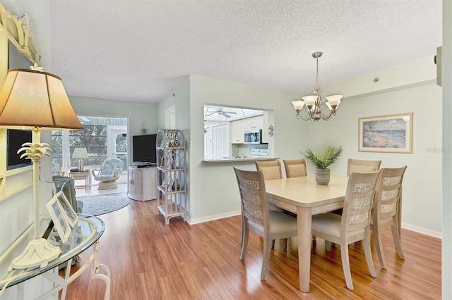 7301 29th Avenue Dr W Unit 108, Bradenton, FL 34209 - dining area with light wood finished floors, a textured ceiling, a chandelier, and baseboards
