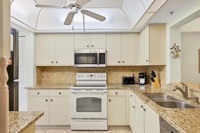 7301 29th Avenue Dr W Unit 108, Bradenton, FL 34209 - kitchen with appliances with stainless steel finishes, a sink, a ceiling fan, decorative backsplash, and light stone countertops