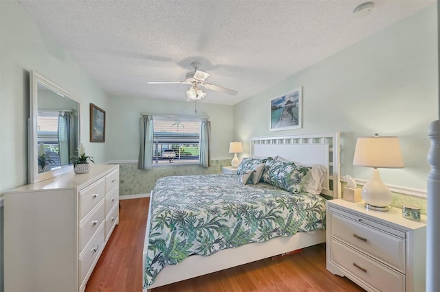 7301 29th Avenue Dr W Unit 108, Bradenton, FL 34209 - bedroom with wood finished floors, a textured ceiling, a ceiling fan, and baseboards