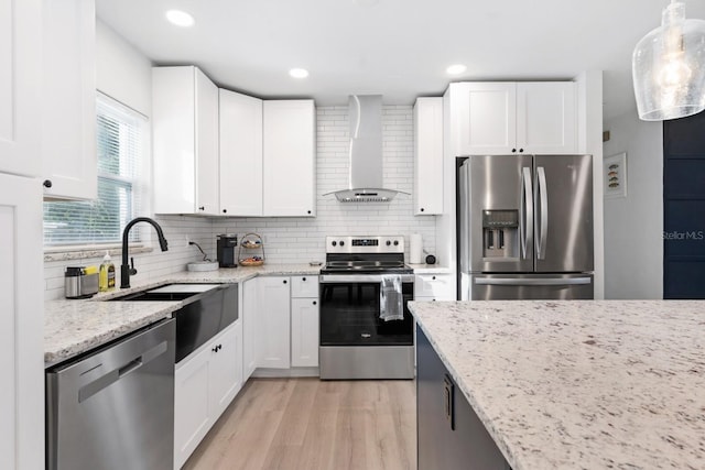 3303 32nd St W, Bradenton, FL 34205 - kitchen with appliances with stainless steel finishes, wall chimney exhaust hood, a sink, light stone countertops, and white cabinetry