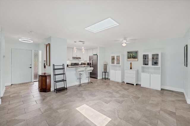 3500 Green View Ct Unit 45, Sarasota, FL 34231 - kitchen featuring stainless steel fridge, a skylight, a kitchen bar, white cabinets, and a ceiling fan