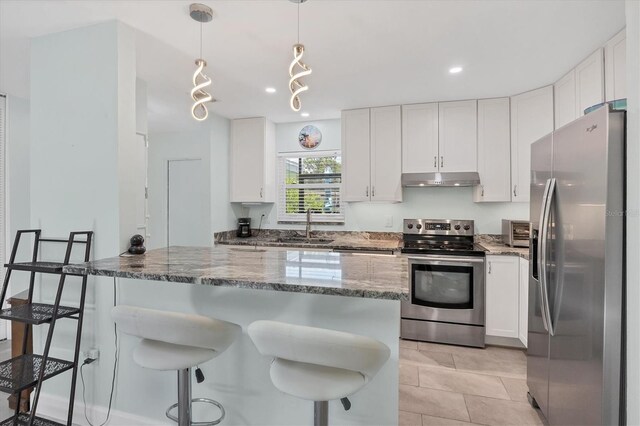 3500 Green View Ct Unit 45, Sarasota, FL 34231 - kitchen featuring appliances with stainless steel finishes, under cabinet range hood, dark stone counters, white cabinets, and a breakfast bar area