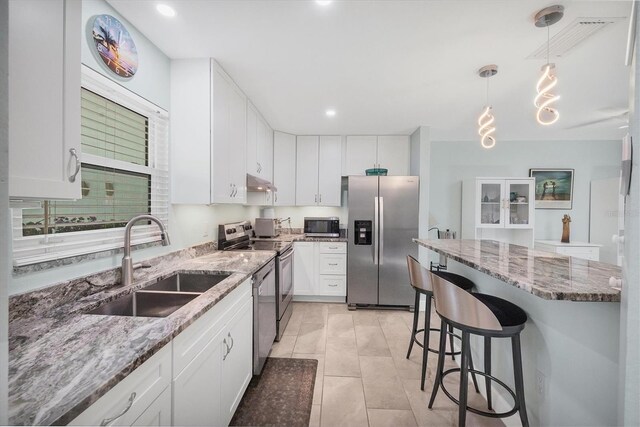 3500 Green View Ct Unit 45, Sarasota, FL 34231 - kitchen featuring stainless steel appliances, a sink, under cabinet range hood, a breakfast bar area, and white cabinetry