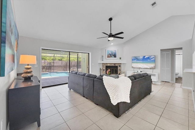 4079 Woodview Dr, Sarasota, FL 34232 - living area featuring a ceiling fan, light tile patterned floors, a glass covered fireplace, and high vaulted ceiling
