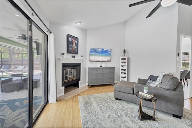 4079 Woodview Dr, Sarasota, FL 34232 - living room with a ceiling fan, wood finished floors, a glass covered fireplace, vaulted ceiling, and baseboards