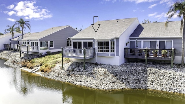 1322 Perico Point Cir, Bradenton, FL 34209 - back of house featuring a sunroom, a deck with water view, and roof with shingles