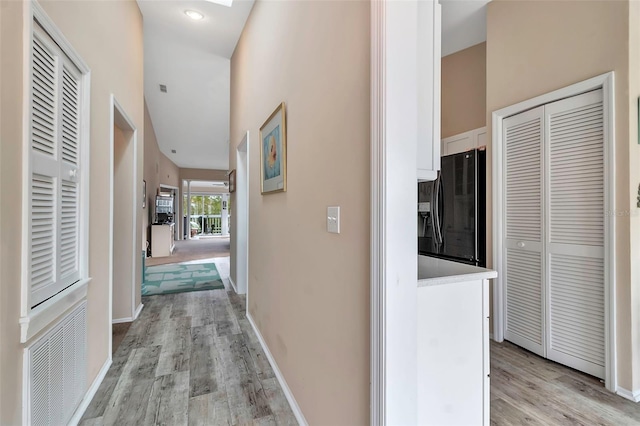 1322 Perico Point Cir, Bradenton, FL 34209 - hallway with light wood-style flooring, a high ceiling, and baseboards