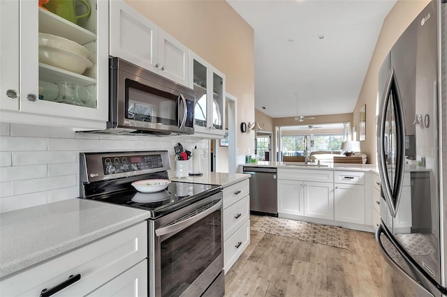 1322 Perico Point Cir, Bradenton, FL 34209 - kitchen featuring stainless steel appliances, light wood-style flooring, decorative backsplash, white cabinetry, and glass insert cabinets