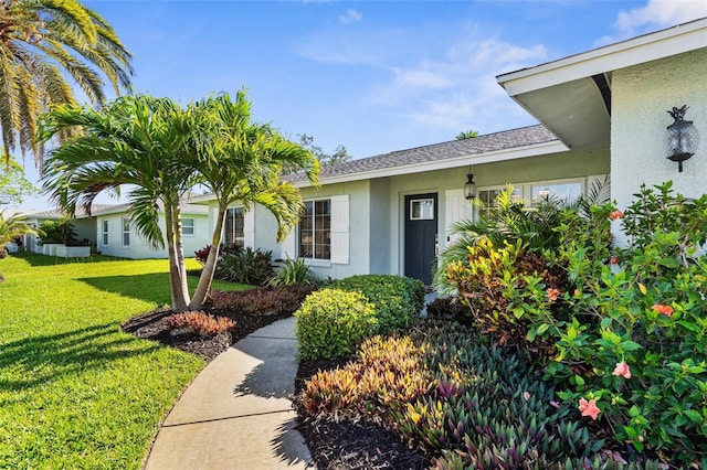 913 64th St W, Bradenton, FL 34209 - doorway to property with stucco siding and a lawn