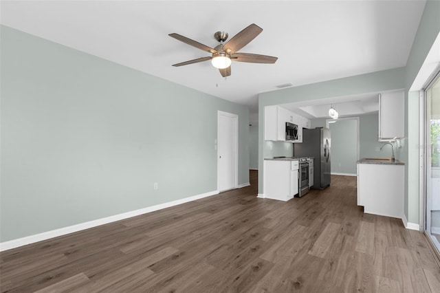 913 64th St W, Bradenton, FL 34209 - unfurnished living room featuring baseboards, dark wood-type flooring, a ceiling fan, and a sink