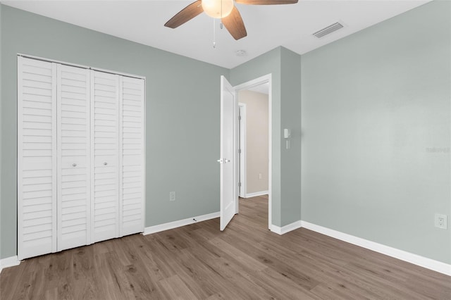 913 64th St W, Bradenton, FL 34209 - unfurnished bedroom with wood finished floors, baseboards, a closet, and ceiling fan