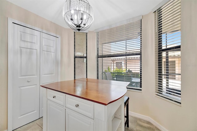 walk in closet with a chandelier and light tile patterned floors