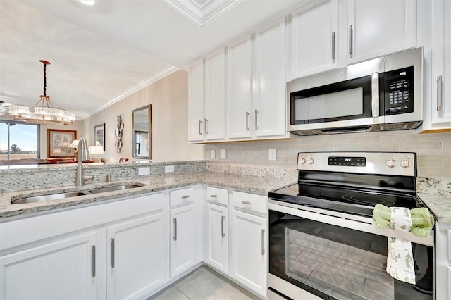 kitchen featuring appliances with stainless steel finishes, a sink, ornamental molding, white cabinets, and a chandelier