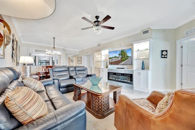 living area featuring a ceiling fan, a glass covered fireplace, ornamental molding, and a chandelier