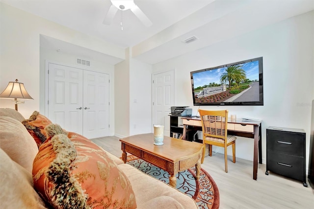 living area with an office area, ceiling fan, light wood-type flooring, and baseboards