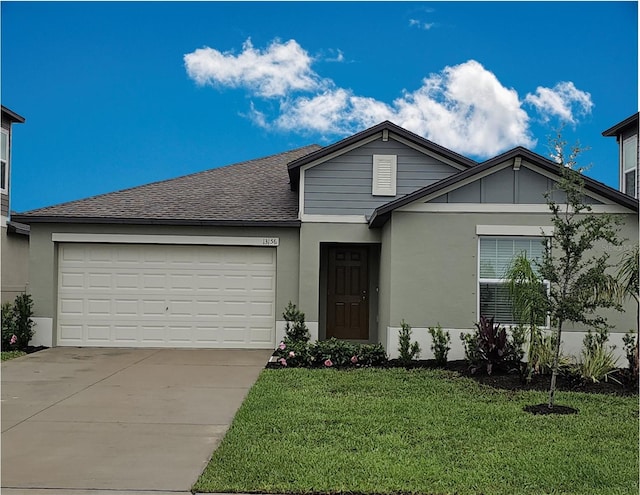 13156 Merlot Sunstone Cv, Parrish, FL 34219 - view of front of home with concrete driveway, an attached garage, a front lawn, roof with shingles, and stucco siding