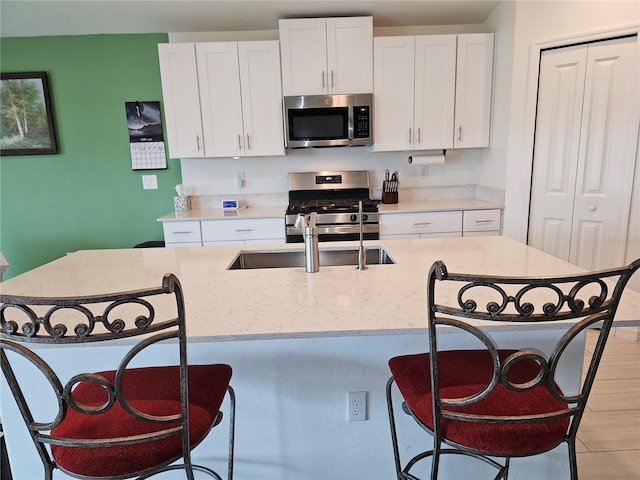 13156 Merlot Sunstone Cv, Parrish, FL 34219 - kitchen featuring appliances with stainless steel finishes, a breakfast bar area, and white cabinets
