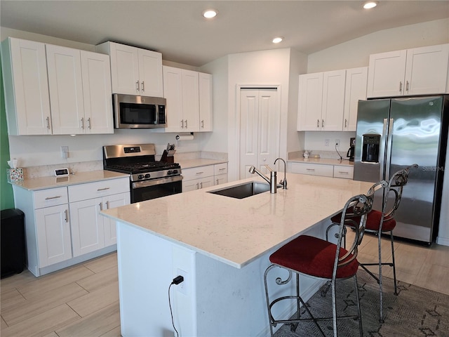 13156 Merlot Sunstone Cv, Parrish, FL 34219 - kitchen featuring stainless steel appliances, a sink, recessed lighting, white cabinets, and a breakfast bar area